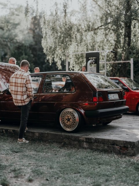 Maroon Golf Mk2 on gold BBS mesh wheels, a man in a plaid shirt leaning in for a look