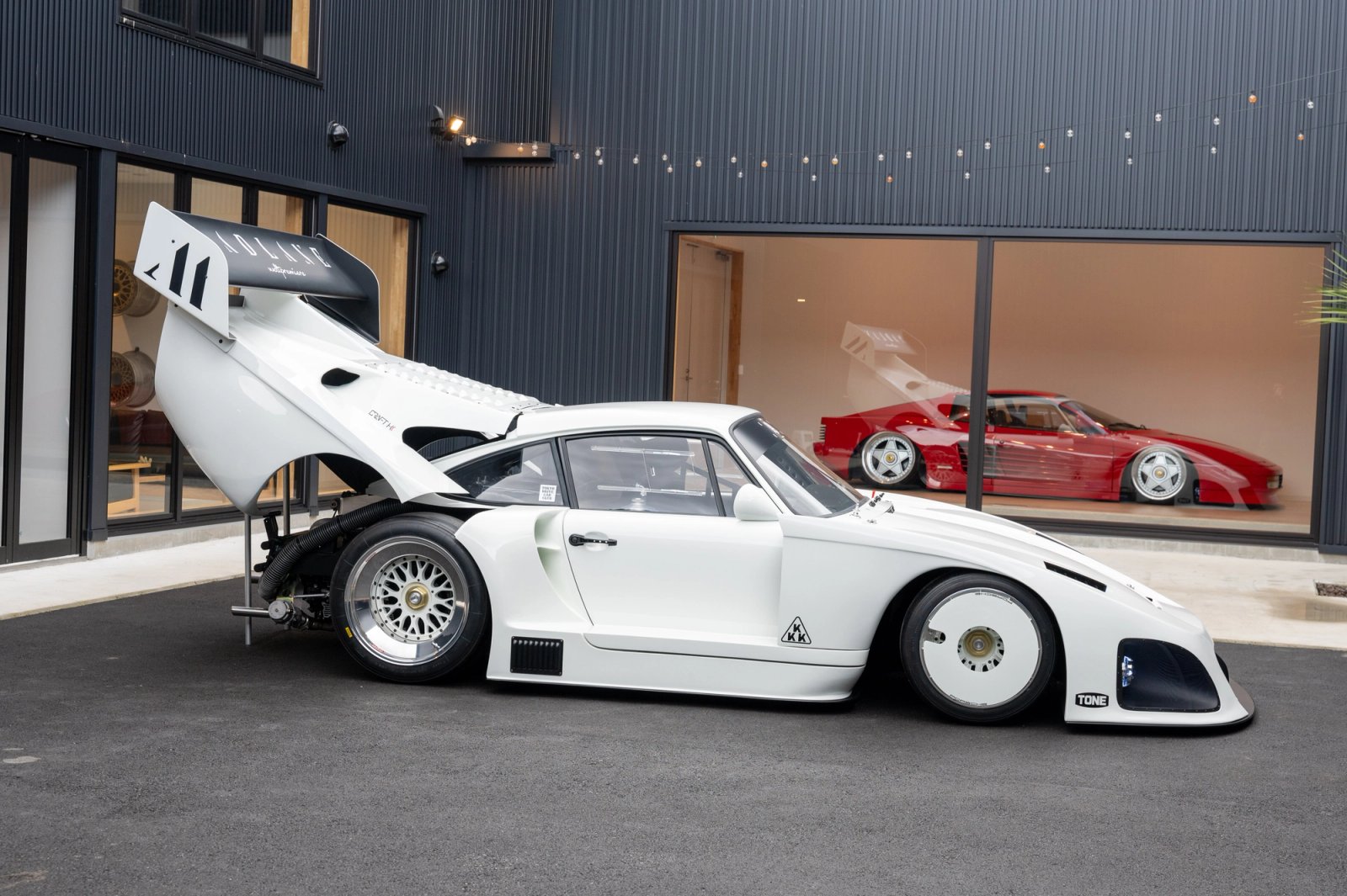 935ML side profile with rear bodywork open, Testarossa visible through the glass behind