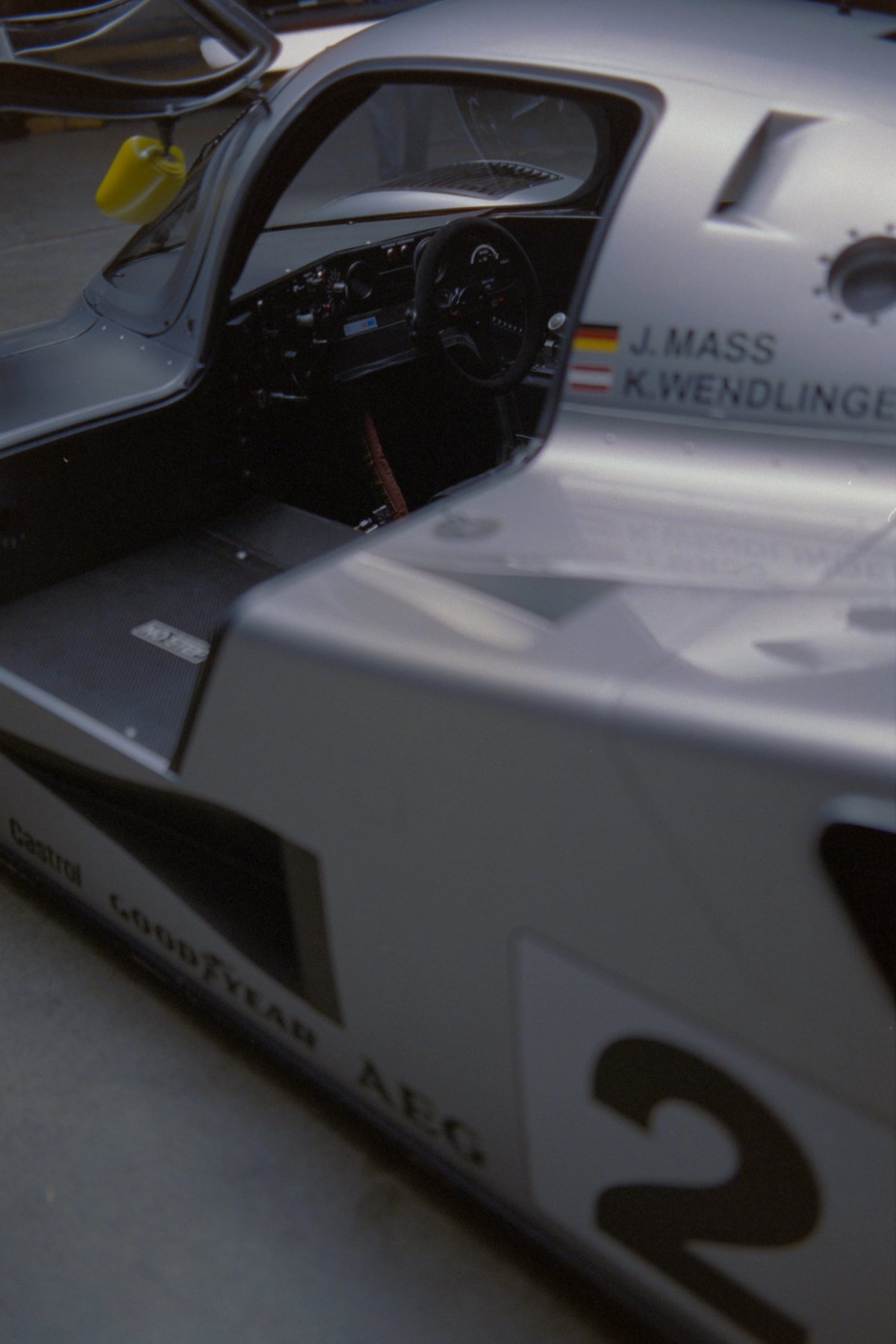C11 cockpit with door open showing J. Mass and K. Wendlinger names, steering wheel and spartan interior