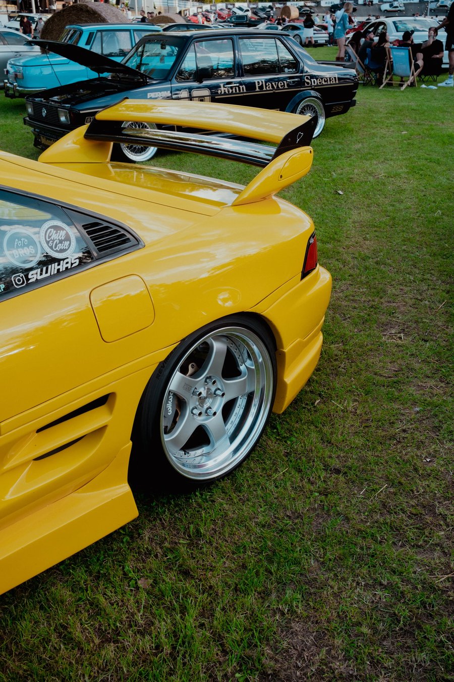 Rear detail of the yellow MR2: polished deep-dish wheel, wide arch and raised rear wing
