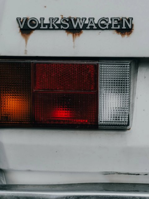 Volkswagen badge with rust streaks above the taillight of a white Golf Mk1