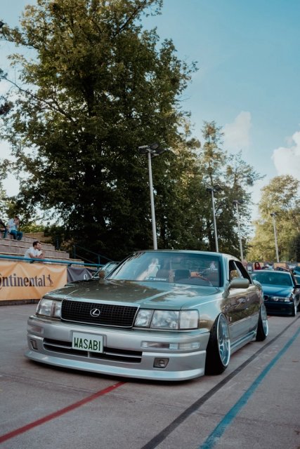 A silver Lexus LS on the track apron, WASABI plate on the front bumper