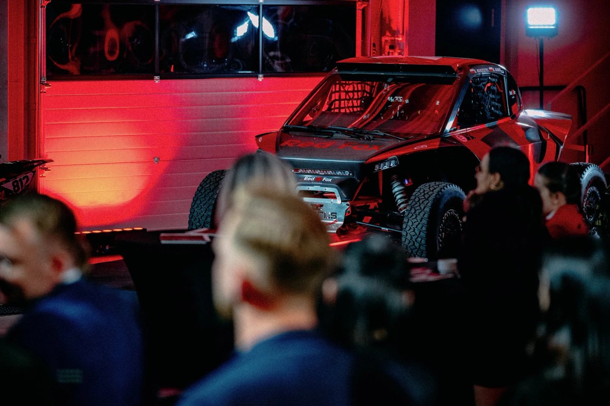 Black Taurus rally raid car front detail with Red Fox livery under dramatic red lighting