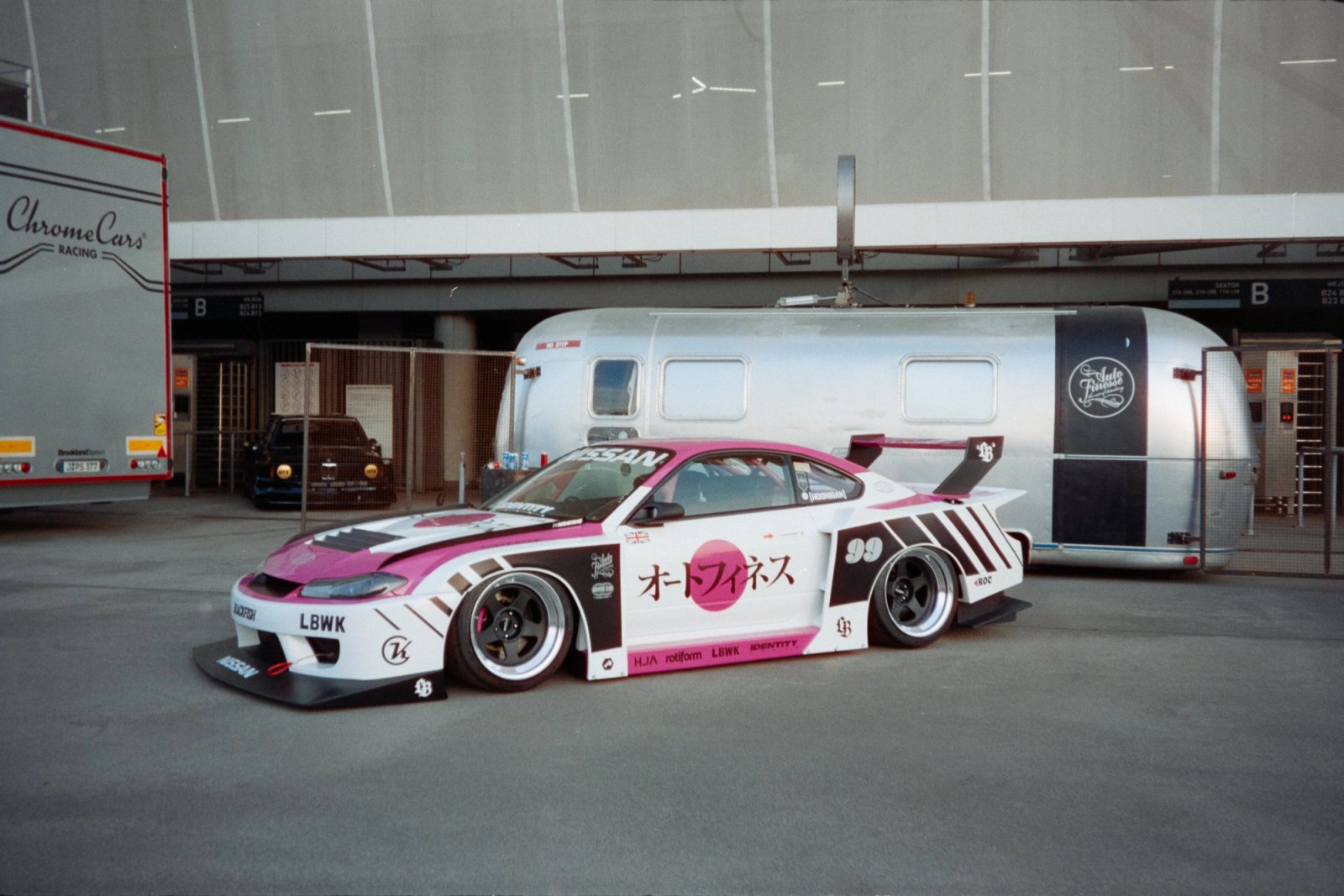 LBWK Nissan Silvia S15 in white and pink Auto Finesse livery next to an Airstream trailer