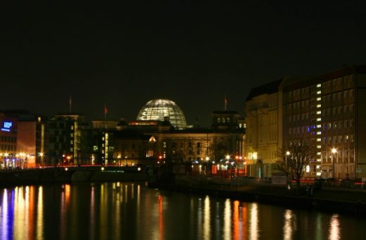 Gece ışıkları altında Spree Nehri ve Reichstag çevresinden Berlin şehir görünümü