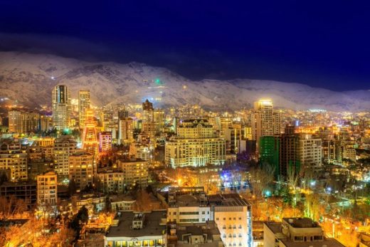Elburz Dağları önünde gece ışıklarıyla Tahran şehir görünümü