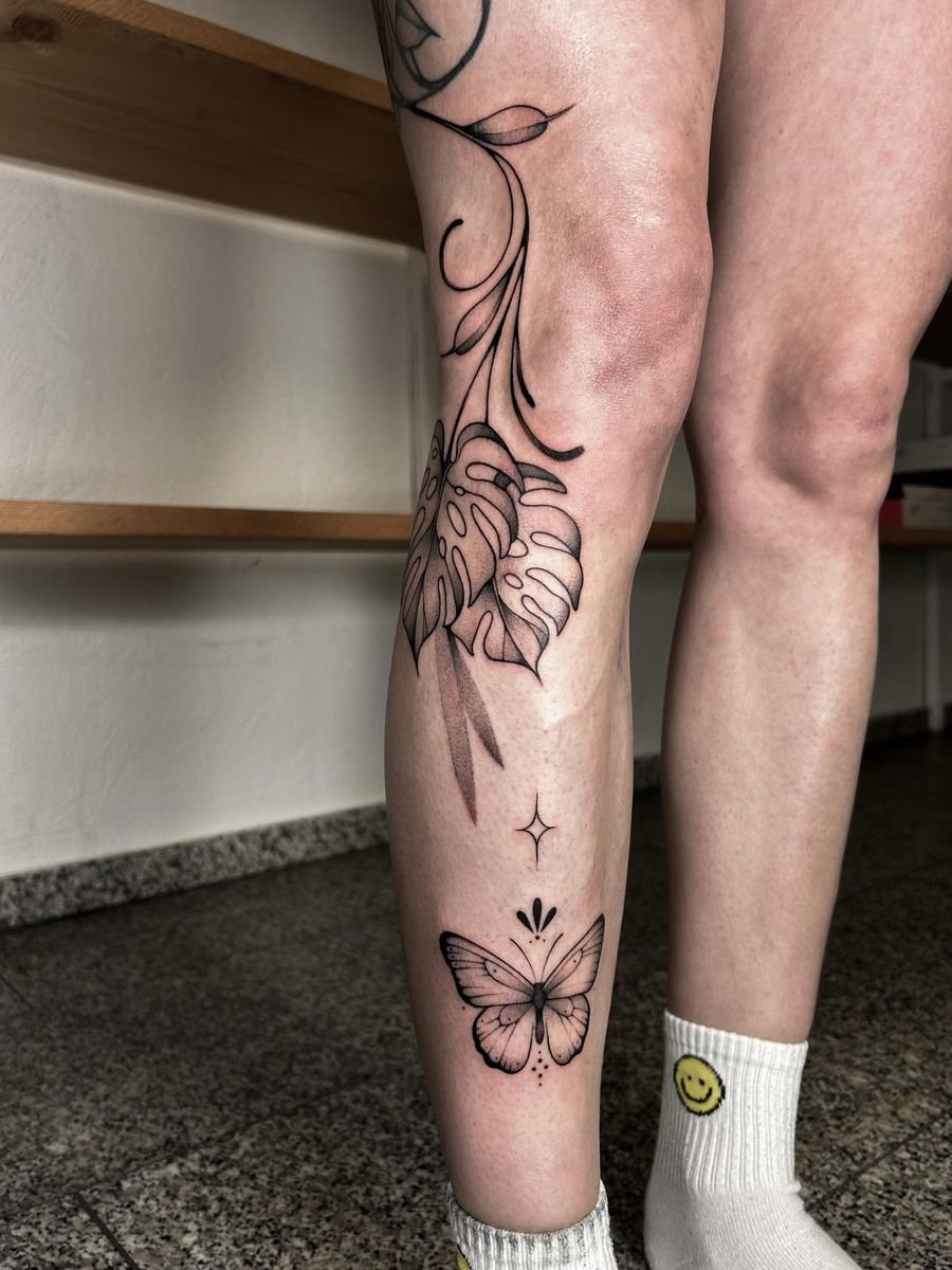 Blütenranke mit Schmetterling am Schienbein, Fineline, von Melinda Dür