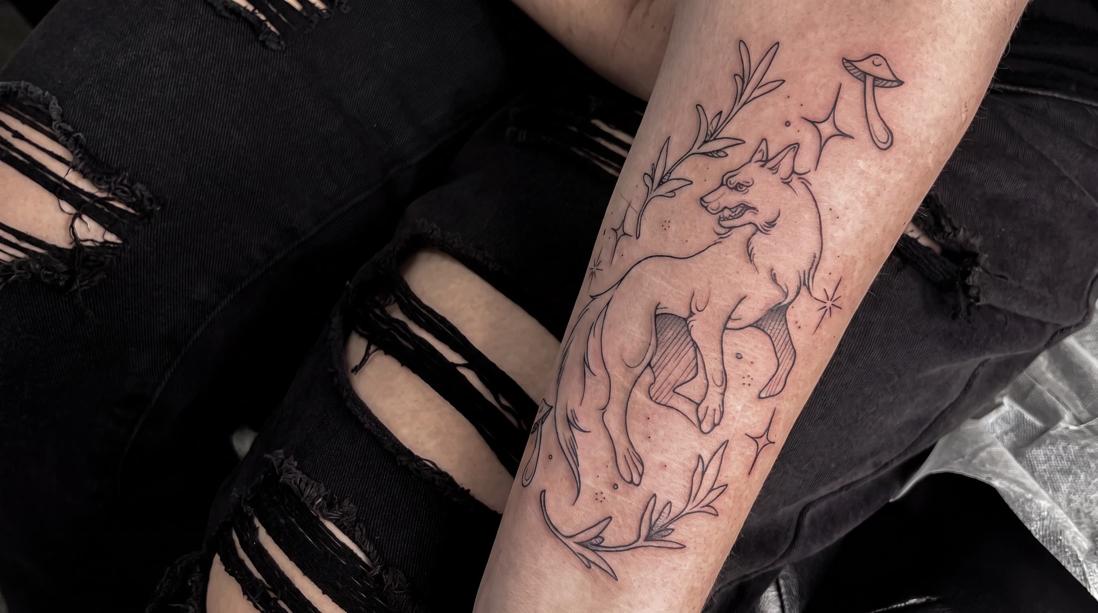 Fineline-Wolf mit Pilz und Zweigen am Bein — Tattoo von Melinda Dür aus Vorarlberg