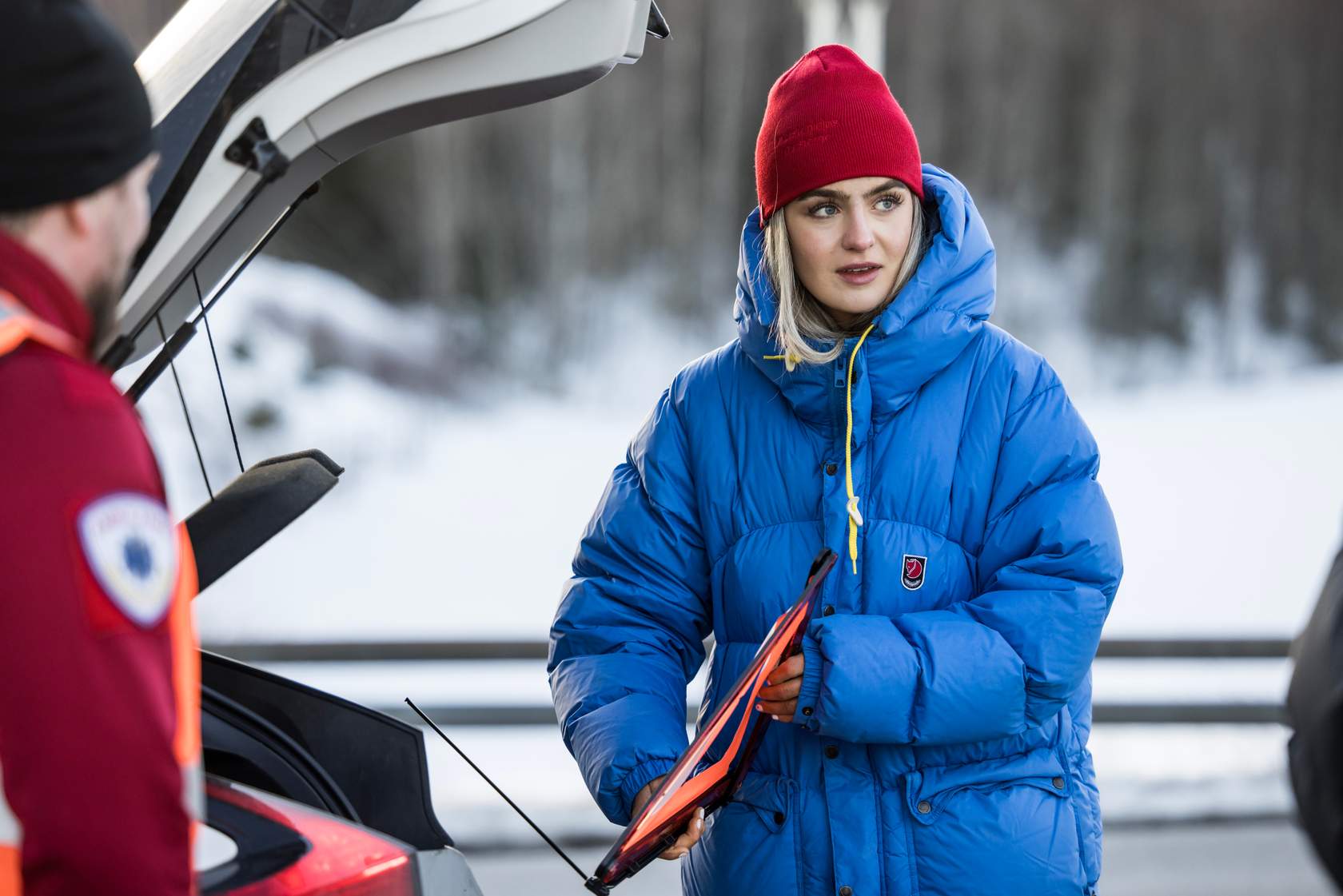 Ung kvinne som tar varseltrekant ut av bilen