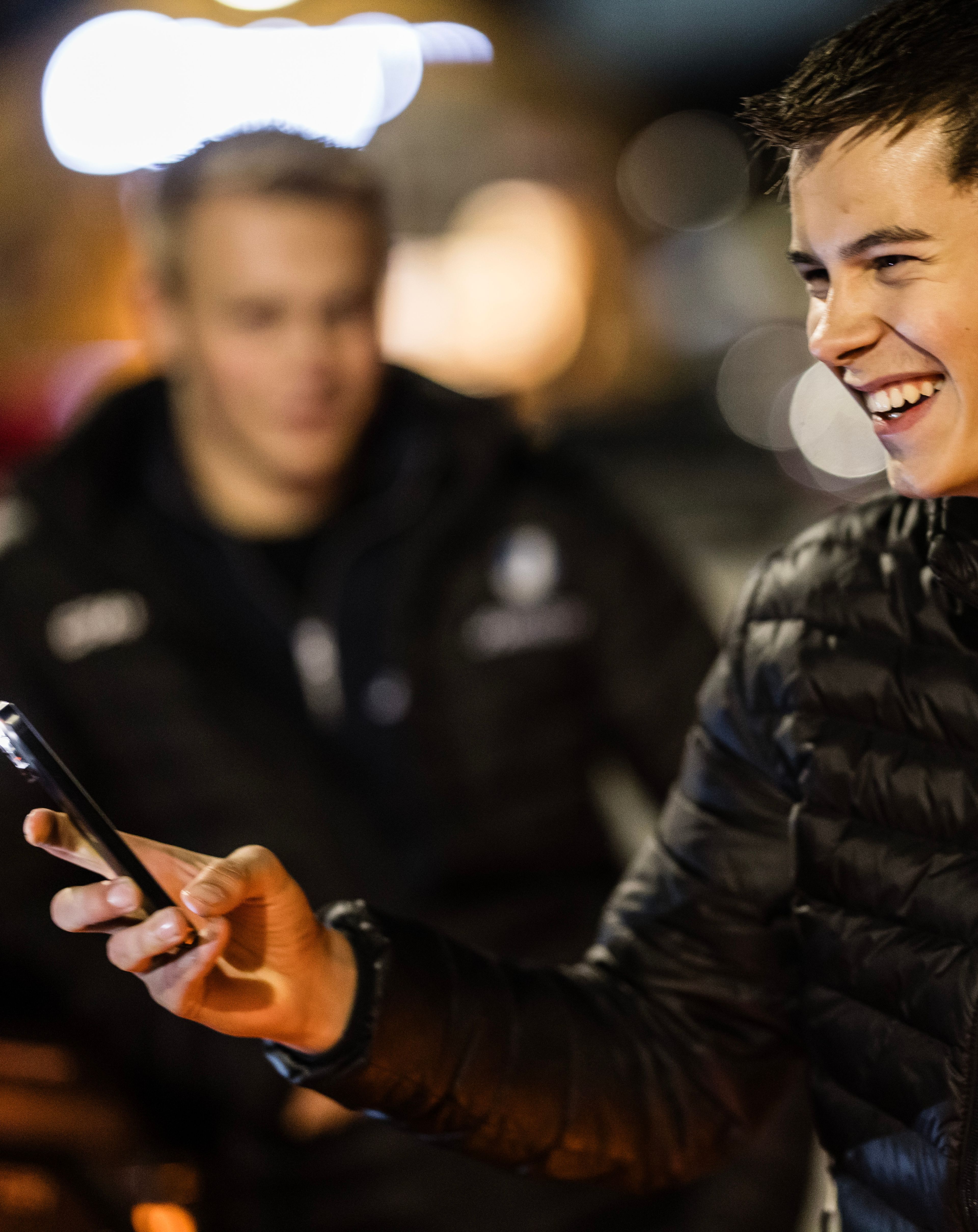 Ungdom ved stasjonsbua tar bilder med mobil