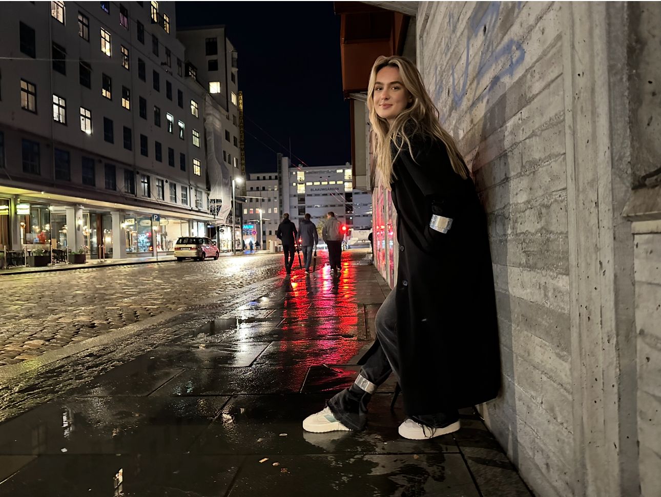 Kvinne som står på fortau om kvelden