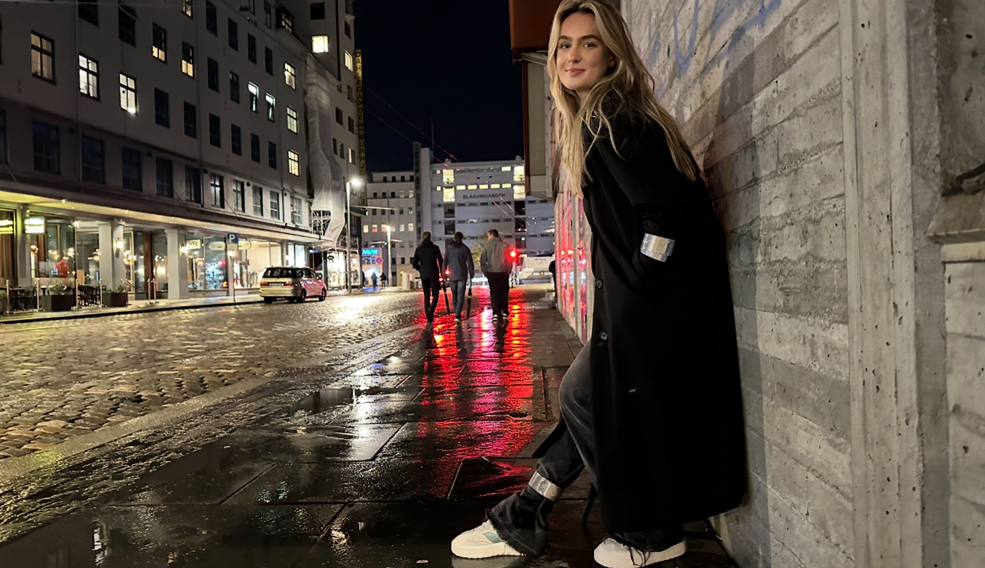 Kvinne som står på fortau om kvelden