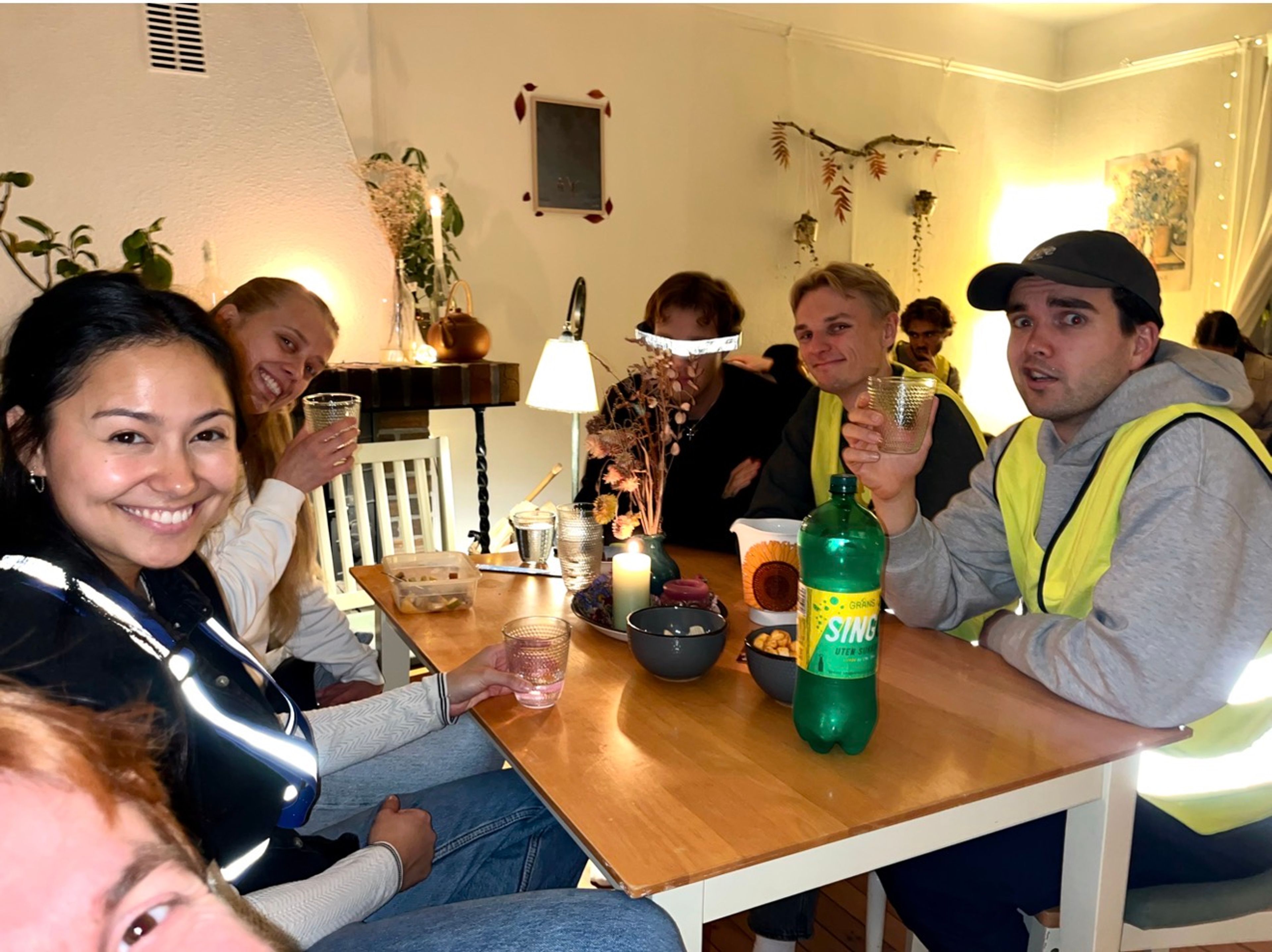 Festdeltakere som sitter rundt et bord med refleksvester