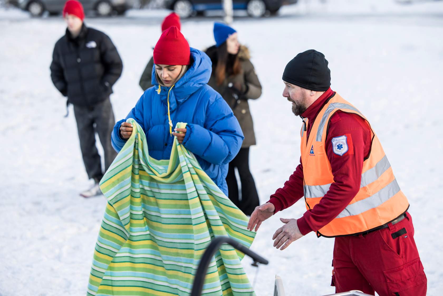 Person holder et teppe med en ambulansesjåfør ved siden av seg
