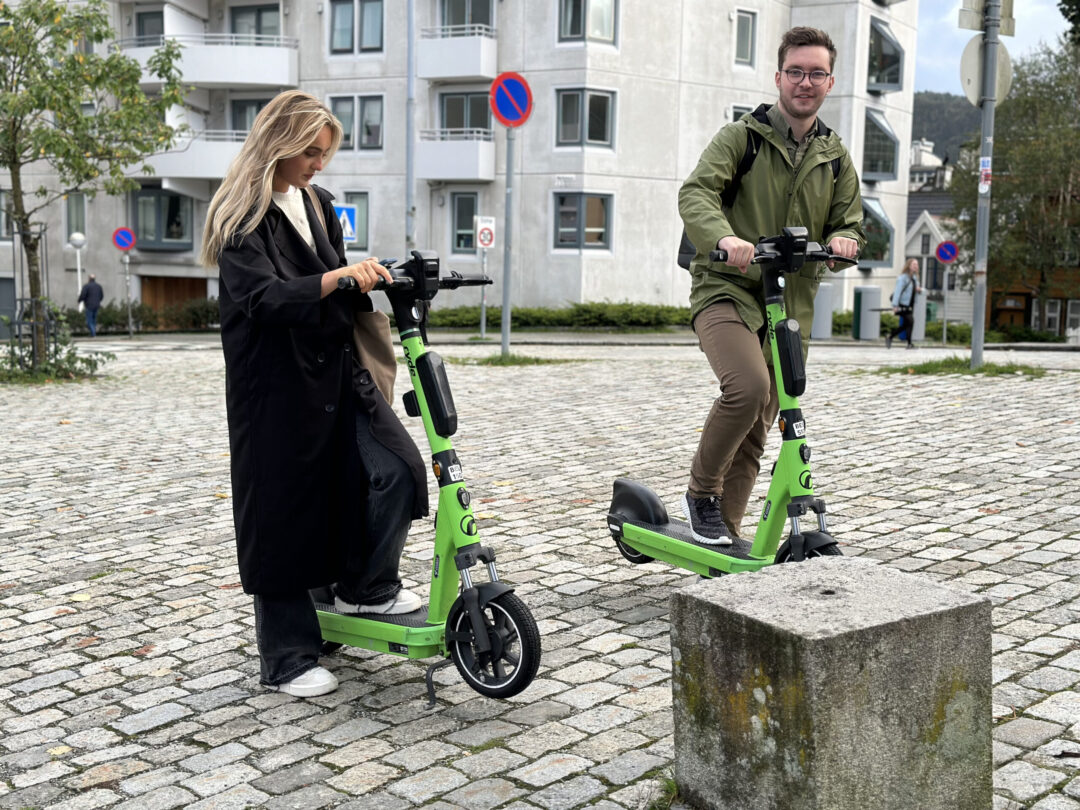 To unge mennesker med grønne sparkesykler