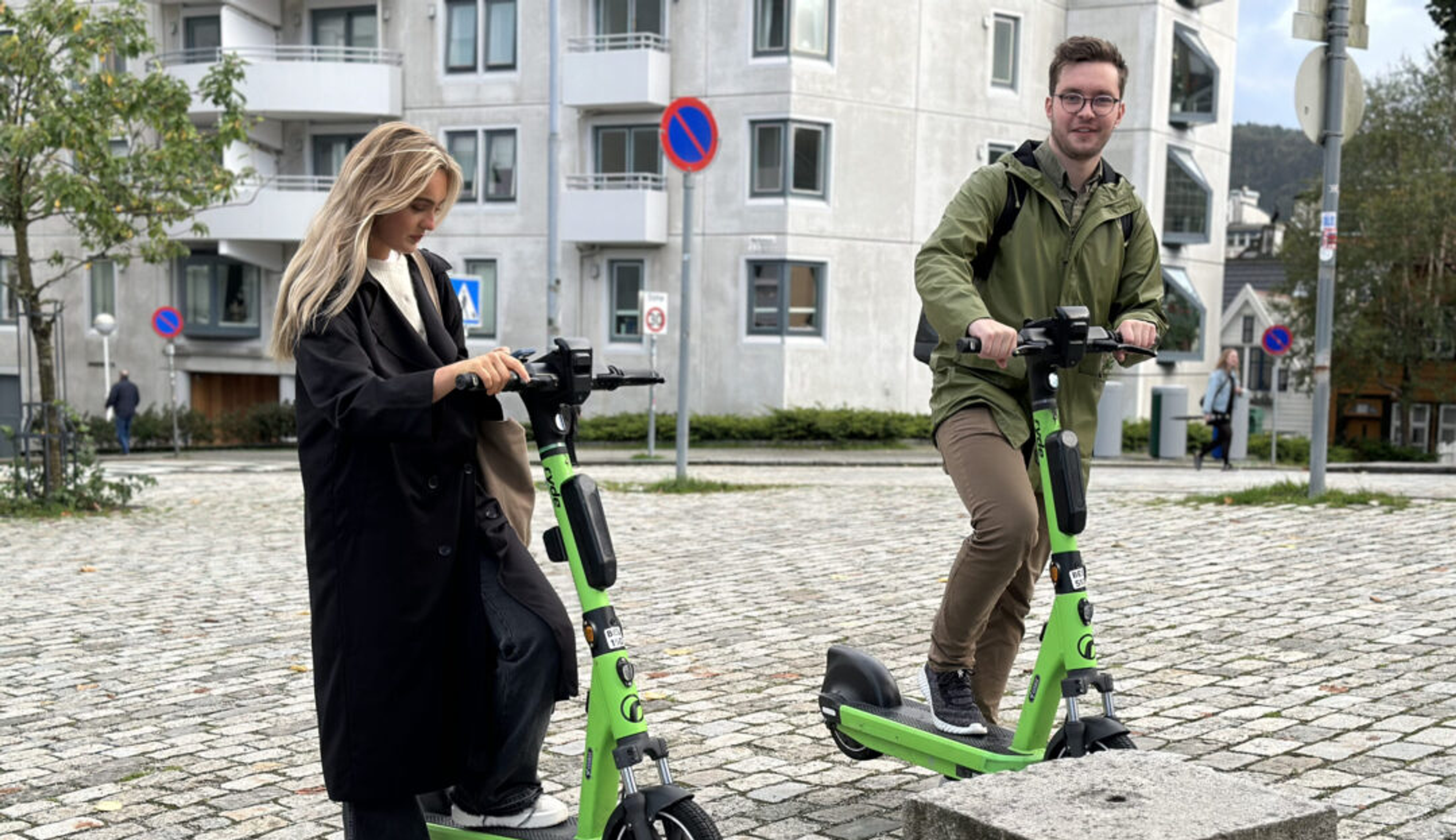 To unge mennesker med grønne sparkesykler