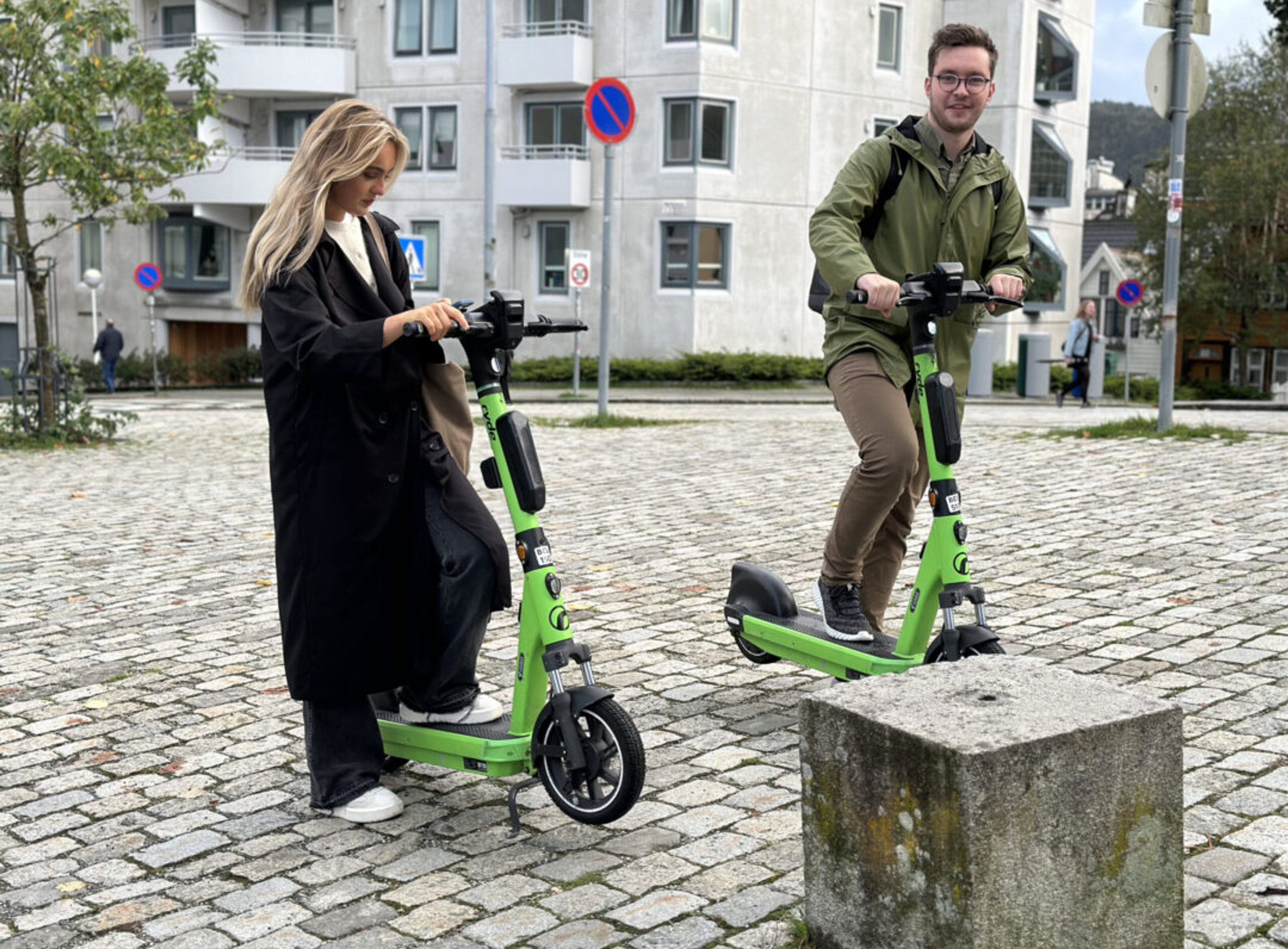 To unge mennesker med grønne sparkesykler