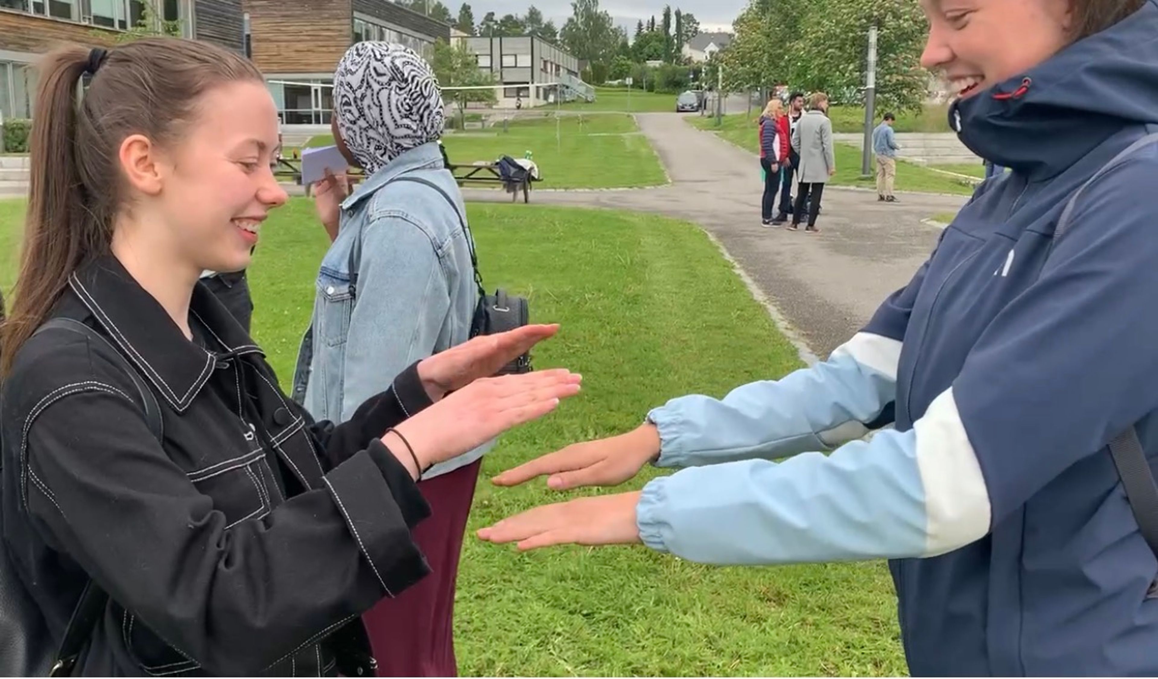 To personer står mot hverandre med hendene mot hverandre