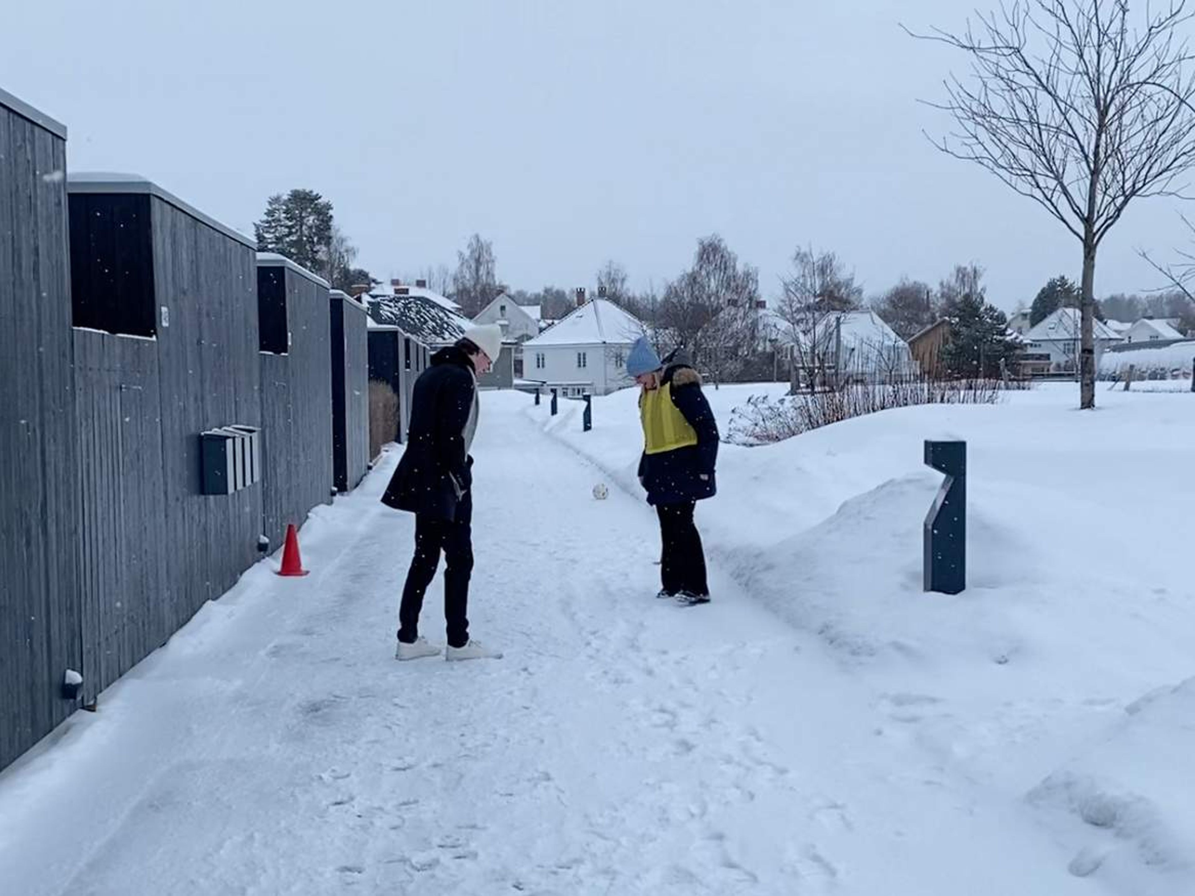 To personer måler opp hvor lang stopplengden var etter løping på snø.