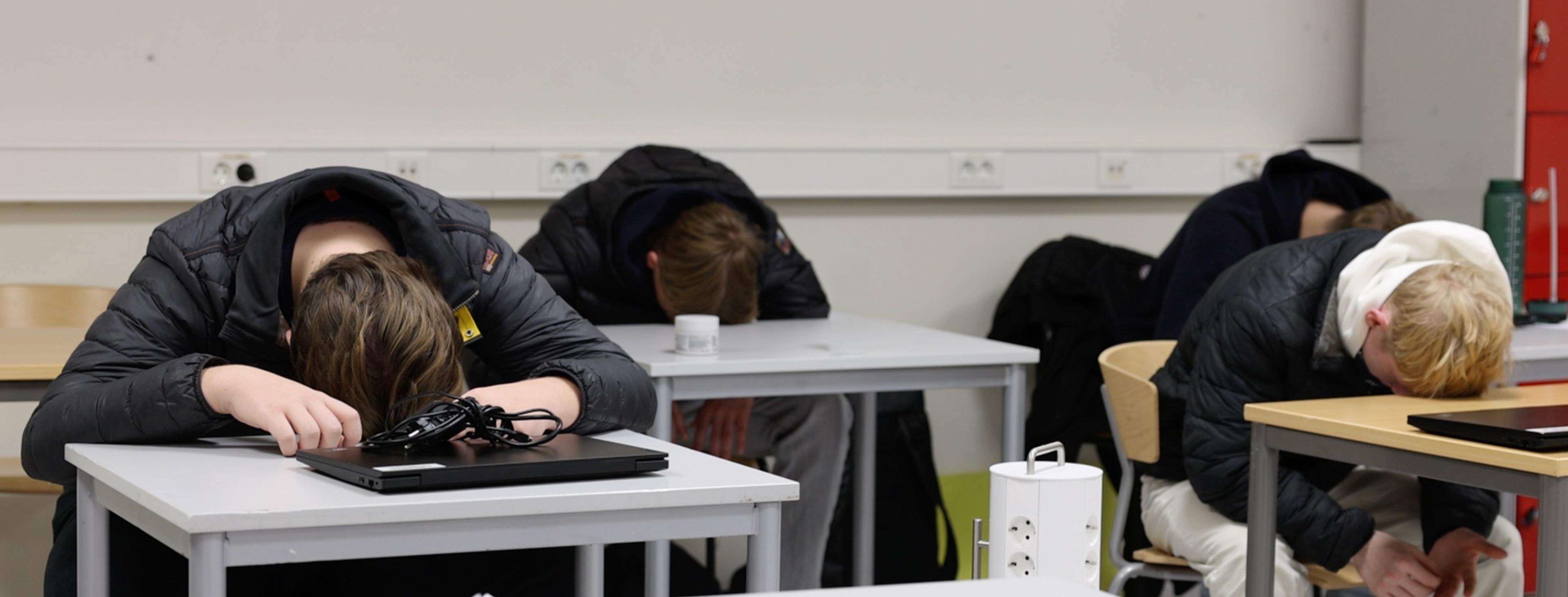 Elever i klasserommet legger hodene på bordet