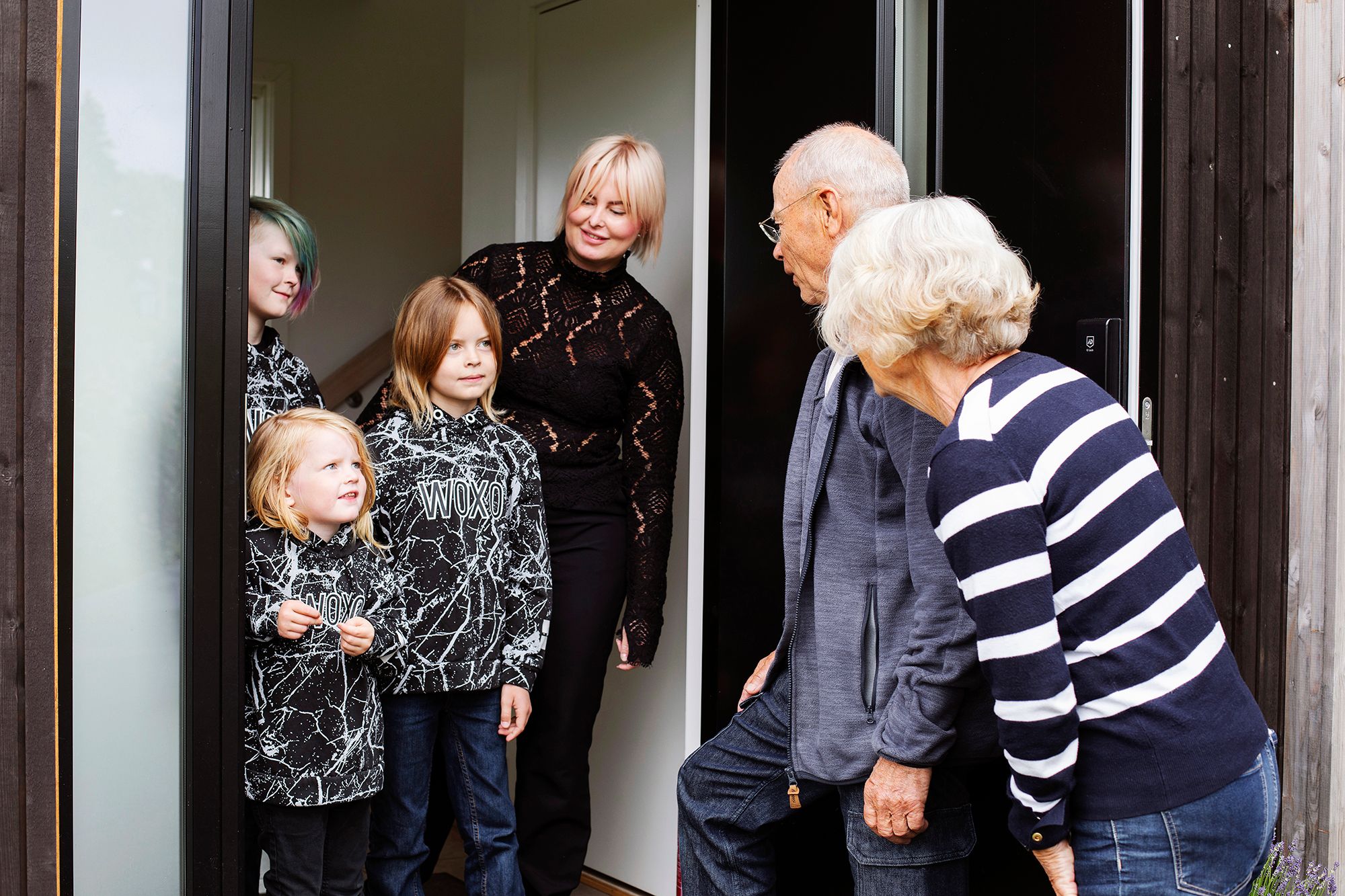 To familiekontaker i døråpning snakker med mor og hennes 3 sønner.
