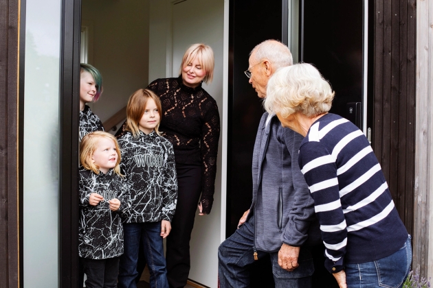 To familiekontaker i døråpning snakker med mor og hennes 3 sønner.