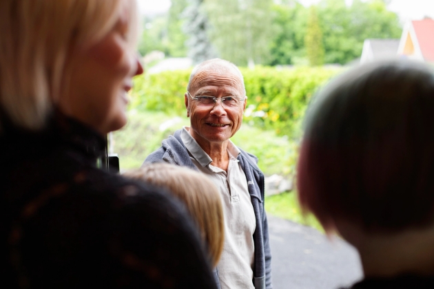 Familiekontakt i døråpning og mor med to sønner med ryggen til.