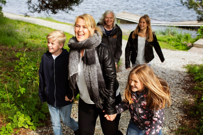 Mor med eldre barn går tur med familiekontakt.