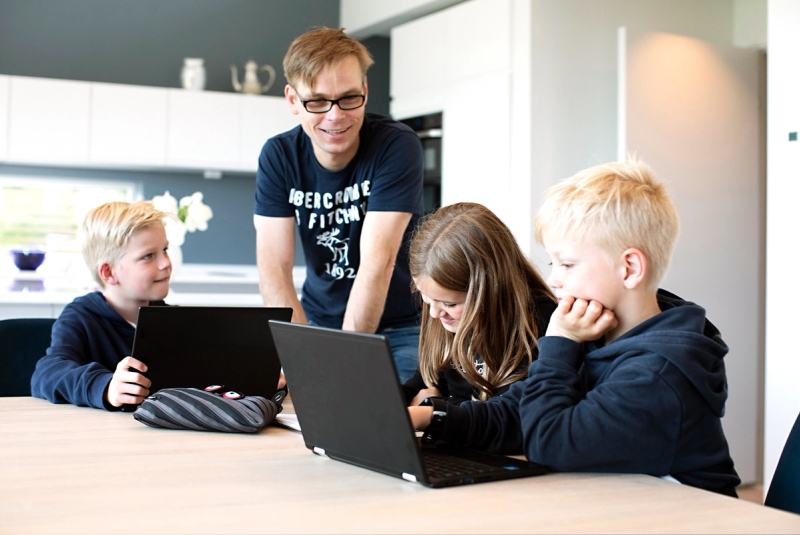 Familiekontakt hjelper 3 barn med lekser.