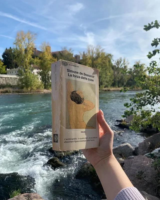foto di un libro in riva al fiume paesaggio luminoso