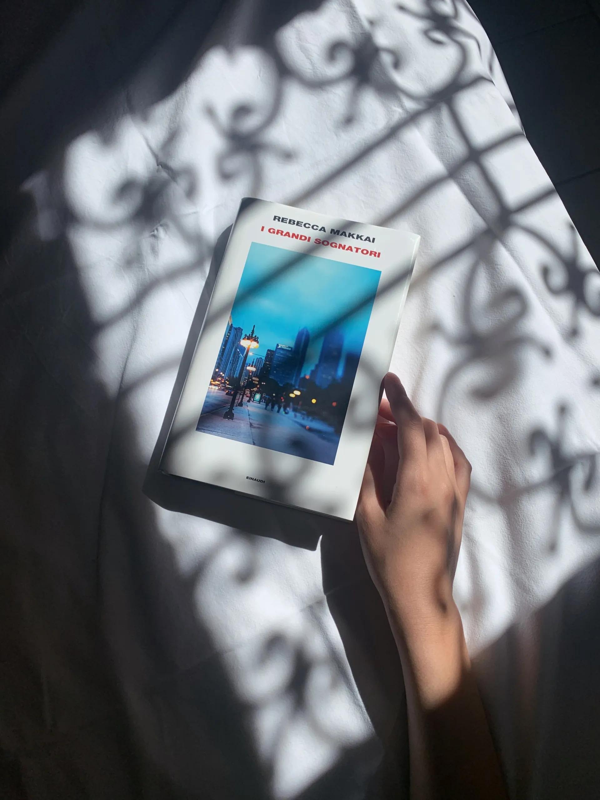 libro sul letto con mano, gioco di luci