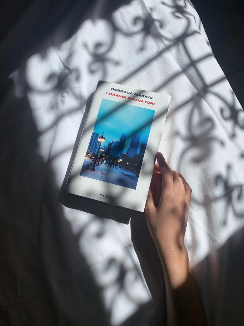 libro sul letto con mano, gioco di luci