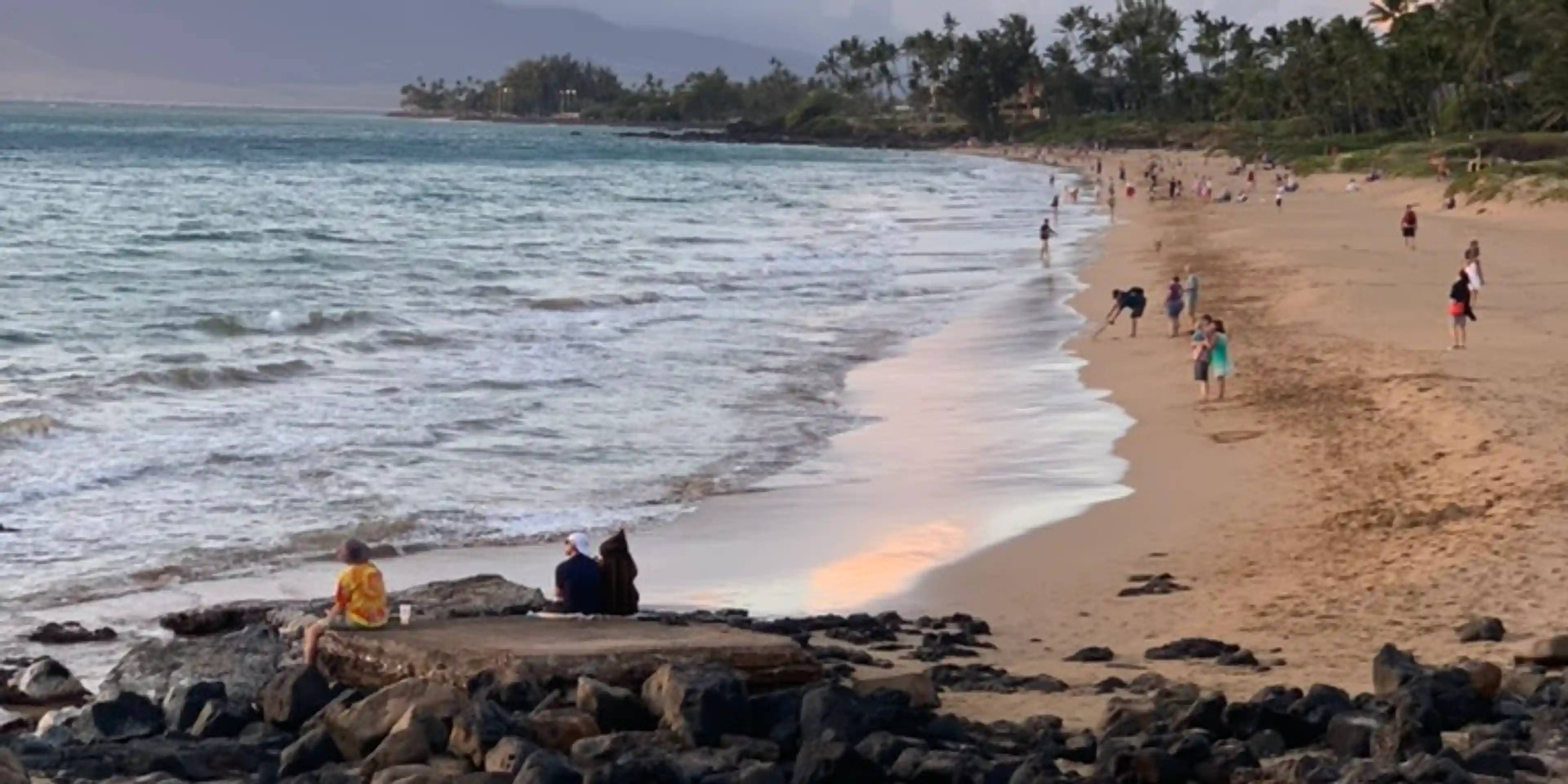 First night on the beach. Long shot of the sand right as the tide comes in at sunset. Mostly clear skies with hues of blue and red.