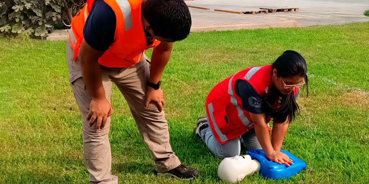 Instructores de Consitec Perú realizando práctica de primeros auxilios y RCP durante una capacitación de seguridad y salud en el trabajo en instalaciones de empresa cliente.