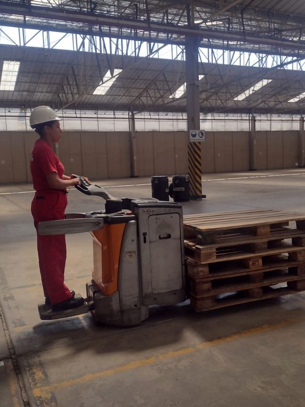 Operador mujer en transpaleta eléctrica