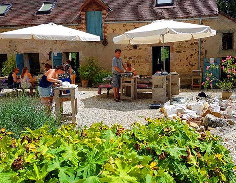 Het binnenplein van Le Moulin, met deelnemers aan het werk in de tuin