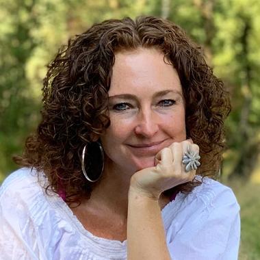 Portret van Yvonne van de Graaf, glimlachend met haar kin op haar hand