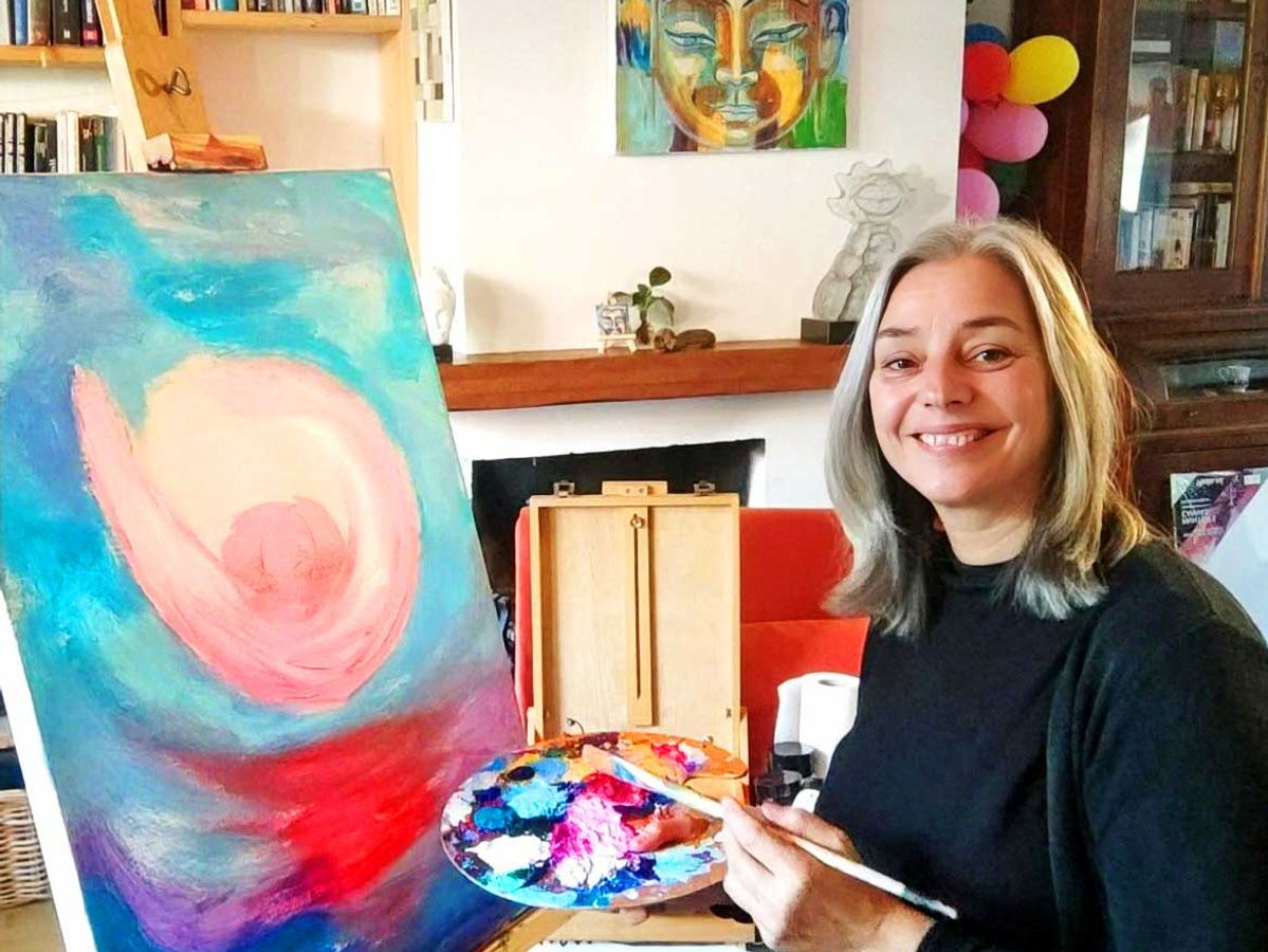 Reina Oversteegen schildert een kleurrijk doek aan de ezel in haar atelier