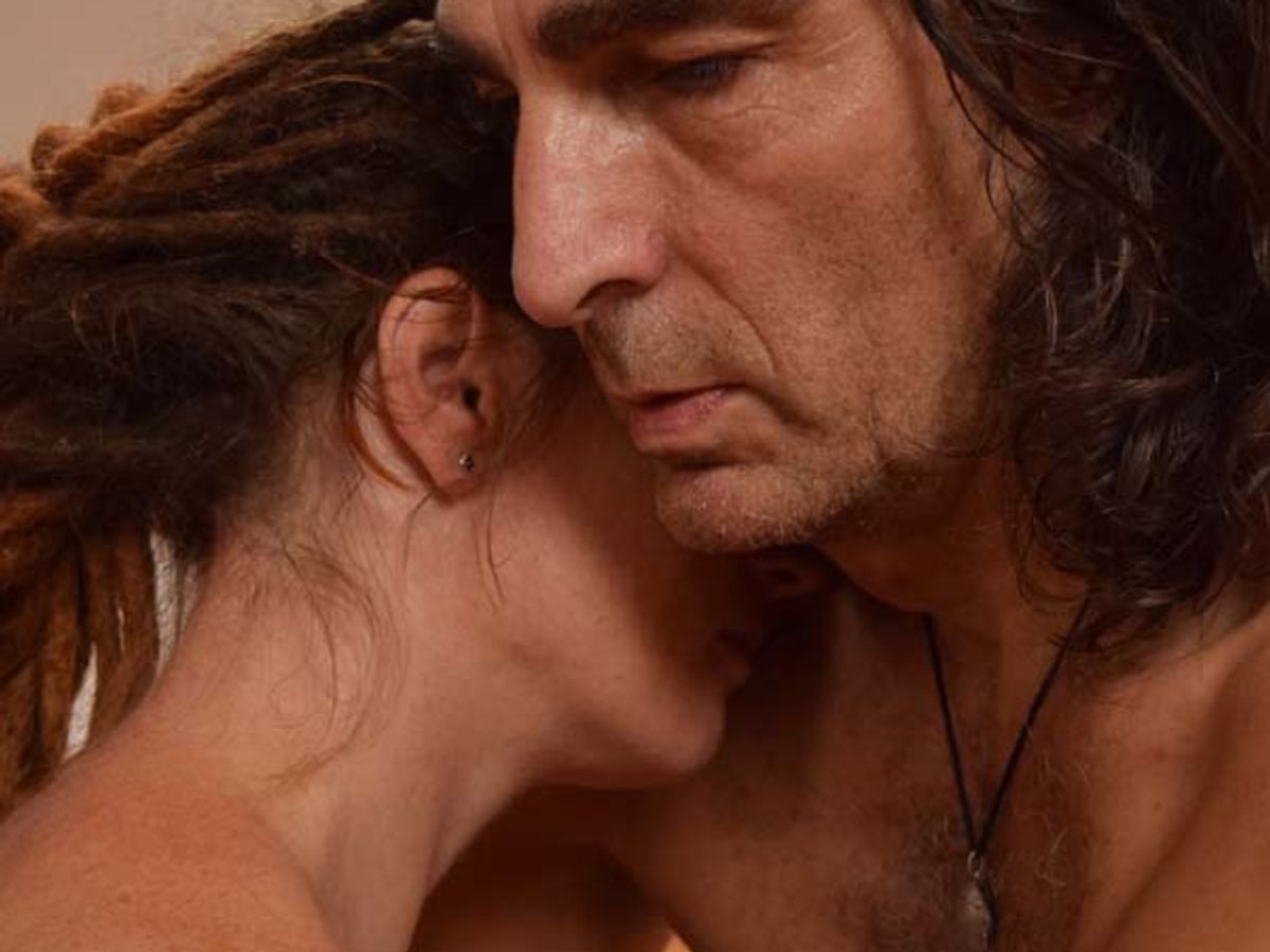Tantra massage in warm licht, een hand raakt zacht het lichaam aan
