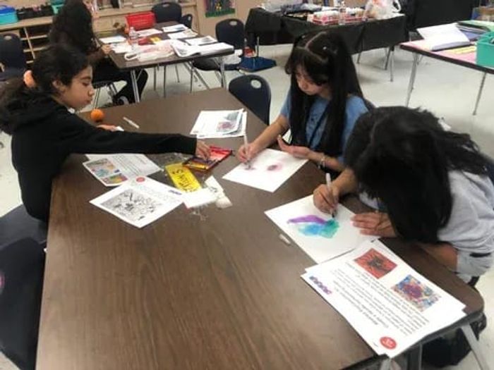 Students at a table drawing what they feel