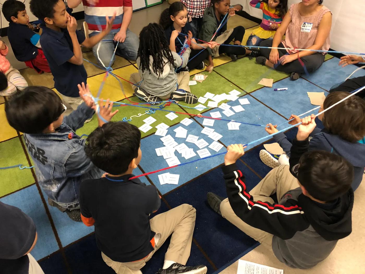Students working together on the floor of a Be Peace – Be Hope session