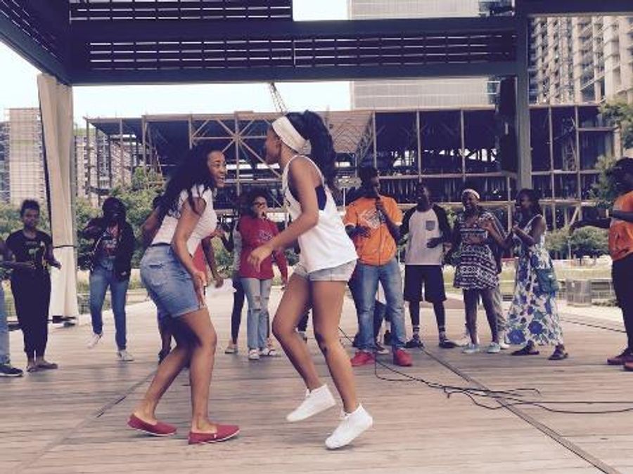 A young person performing spoken word on stage at Discovery Green