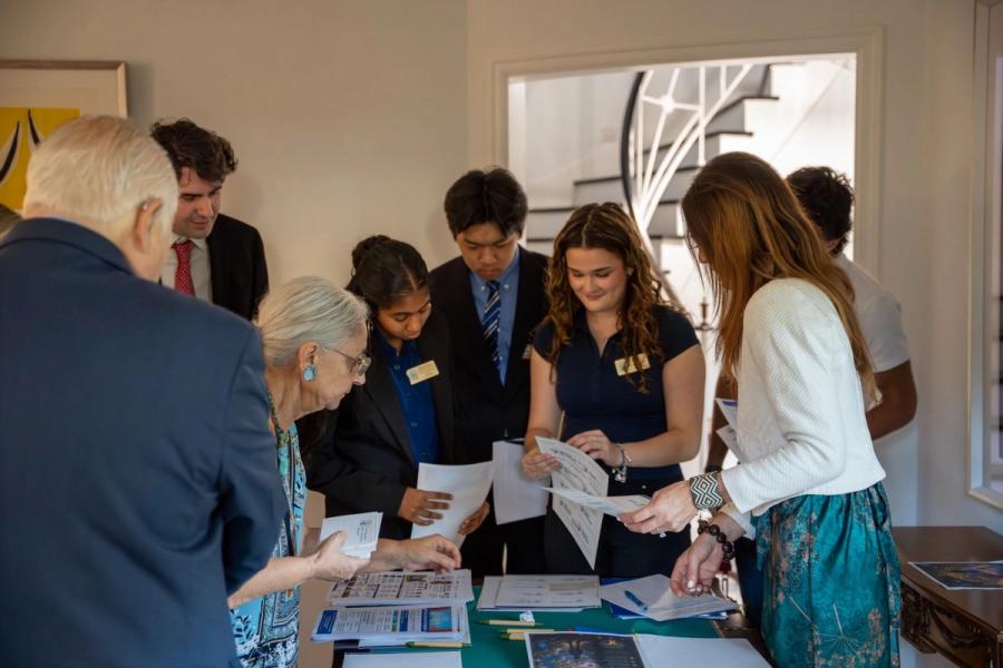 Guests and young volunteers looking through EsperHope materials at the welcome table