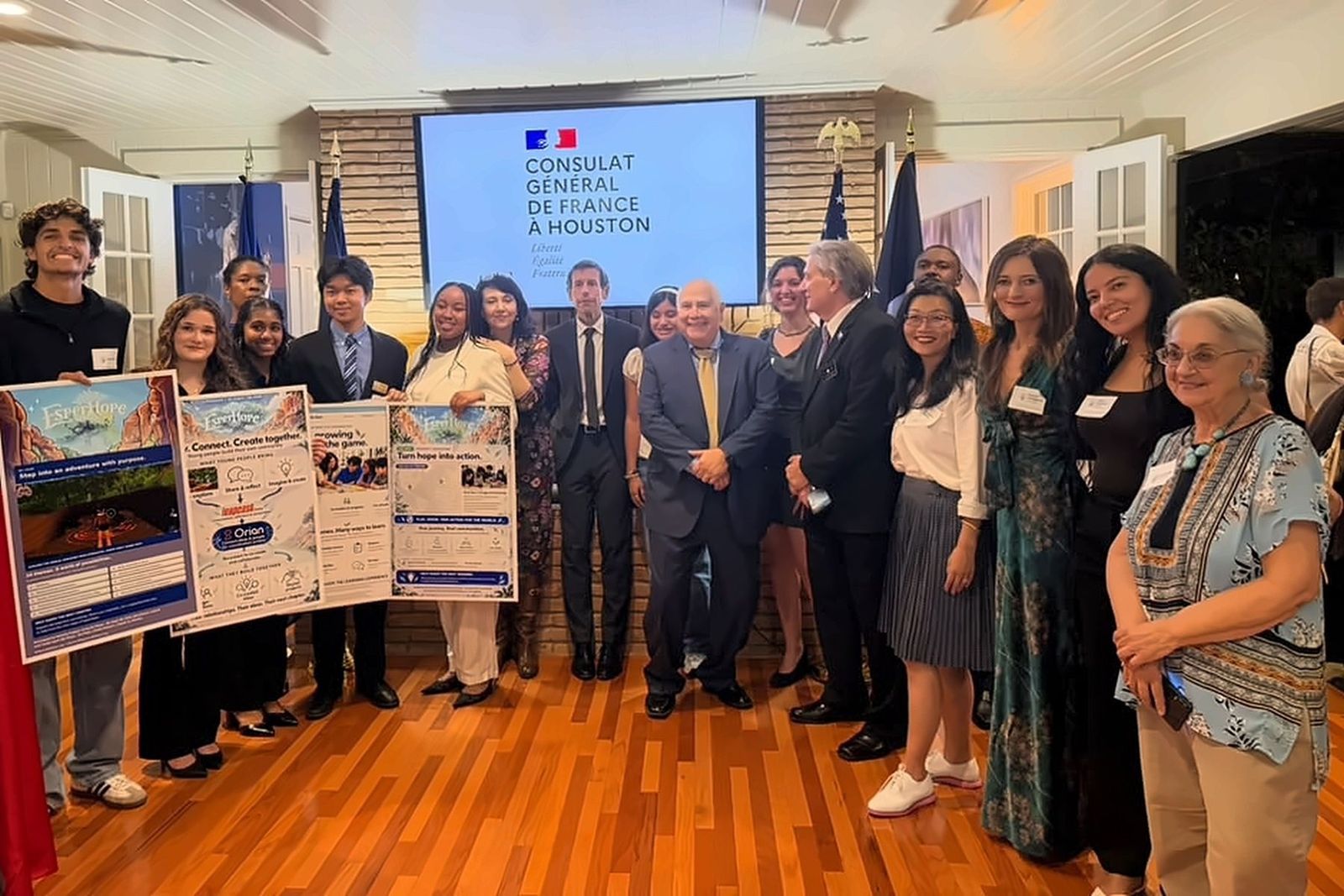Young people, partners and guests together at the Residence de France, in front of the Consulat Général de France à Houston screen