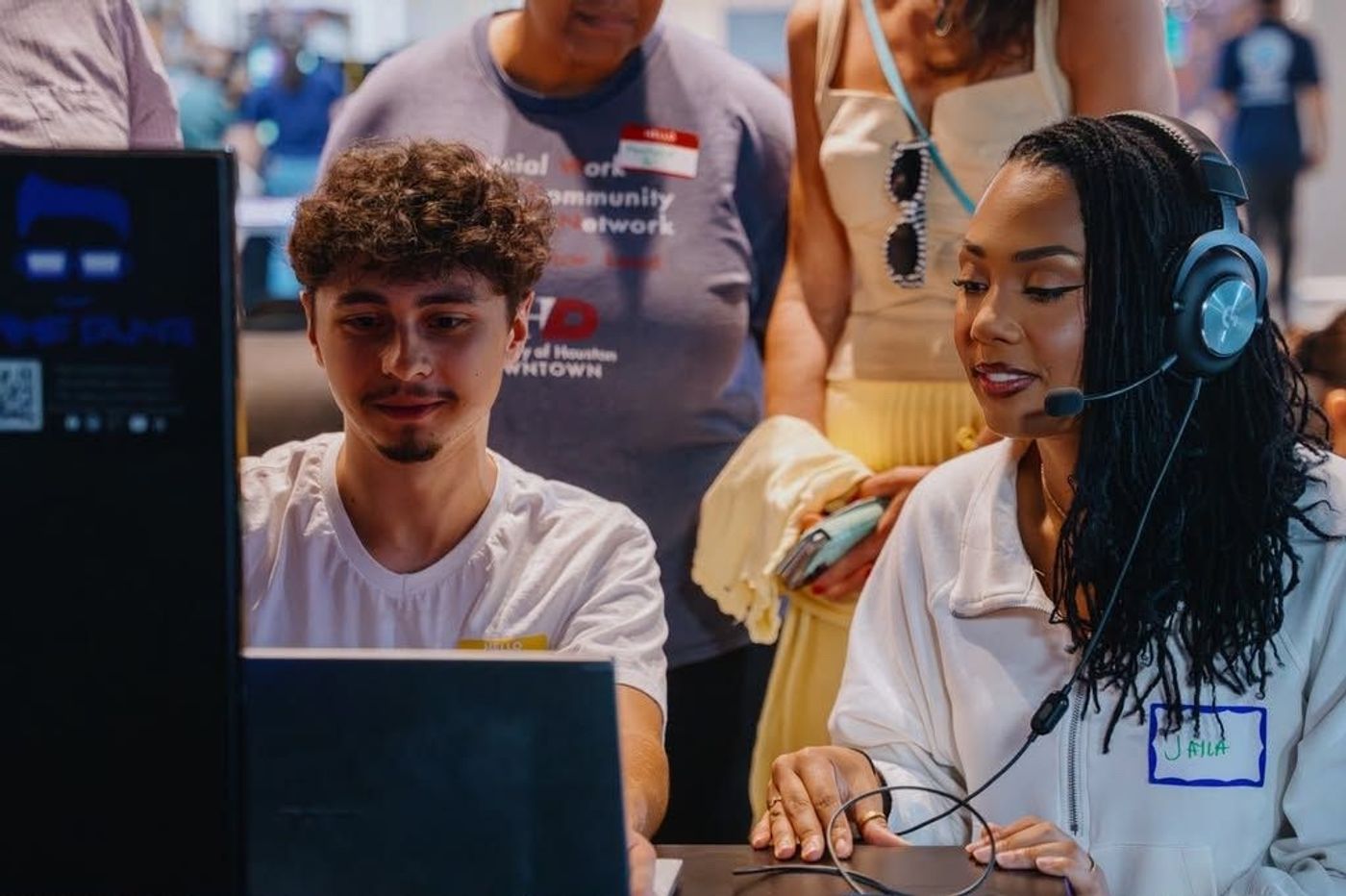 A young woman plays the EsperHope demo with a headset as others look on
