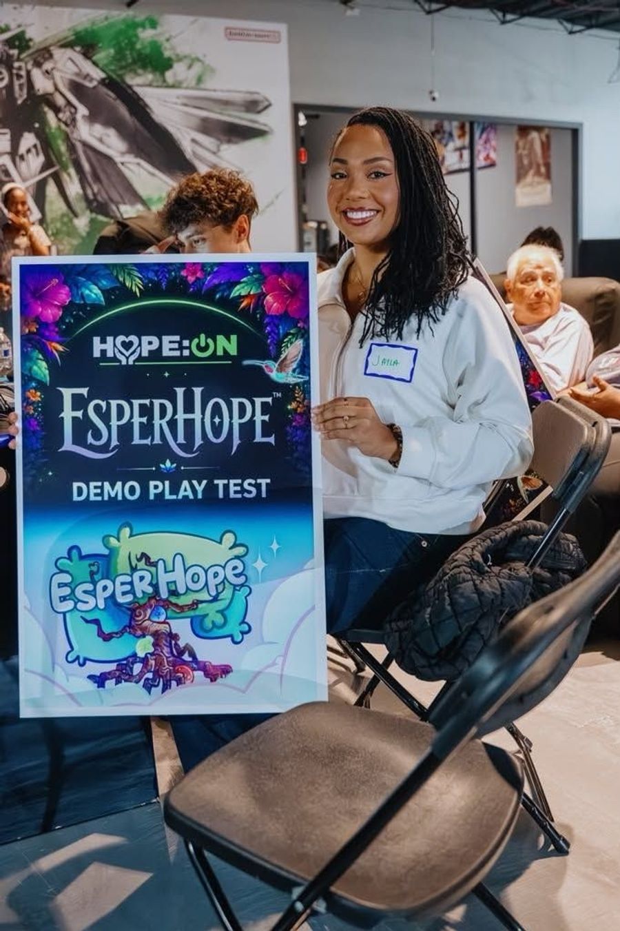 A guest holds the HOPE:ON EsperHope Demo Play Test poster