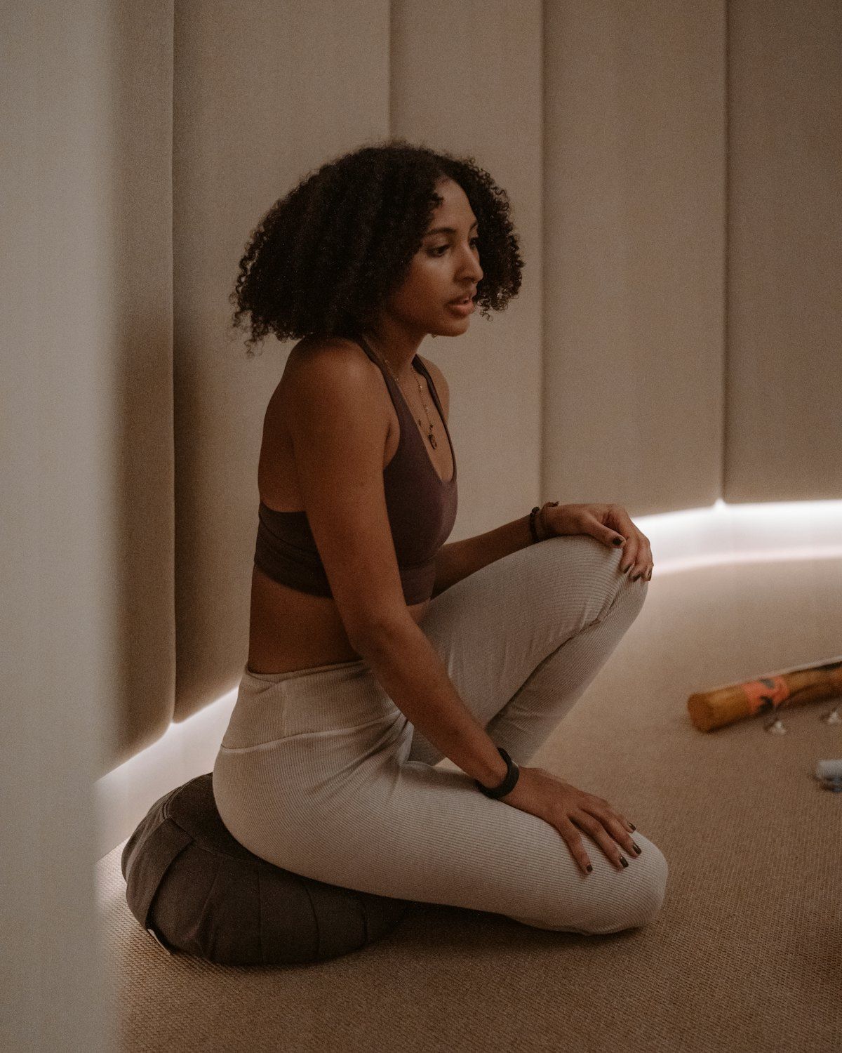 Nora sitting on the floor of a warm, dimly lit room