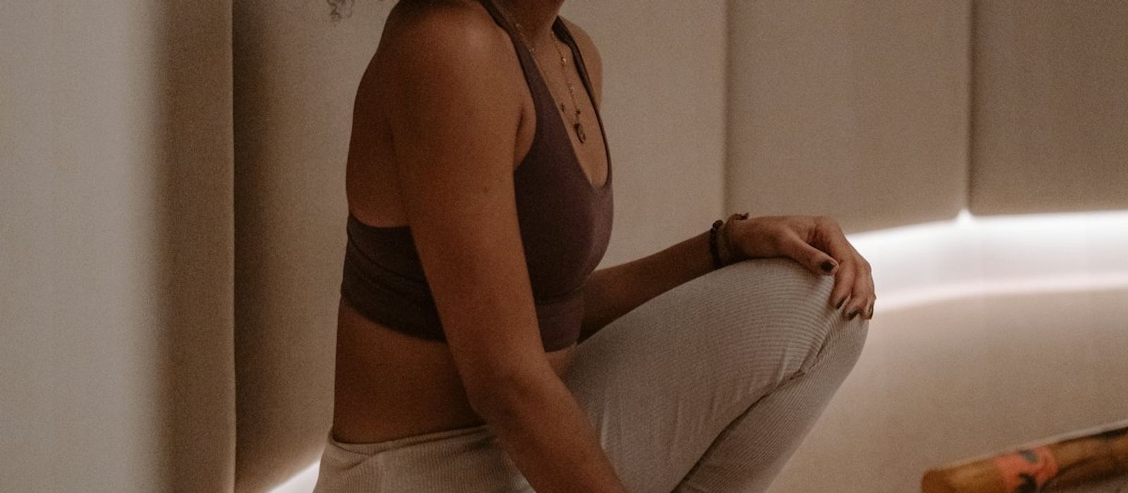 Nora sitting on the floor of a warm, dimly lit room