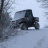 a polaris utility vehicle is driving through the snow