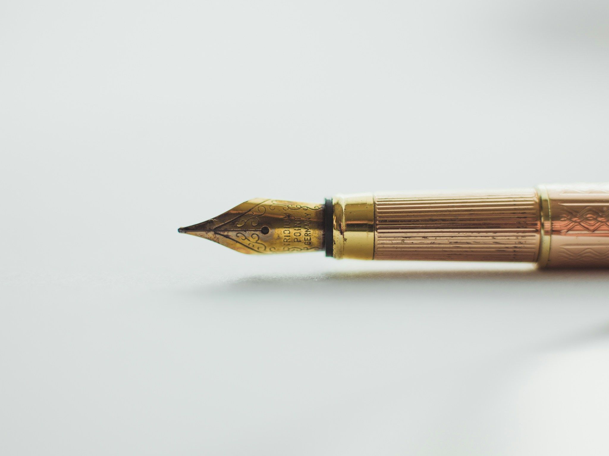 a close up of a fountain pen on a white surface .